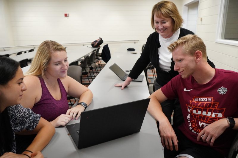 Kimberly Ellis (second from right) checks in on a group of students during The Game to assess their progress. 