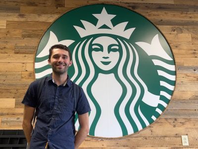 Kevin Sandler in front of the Starbucks logo.