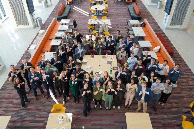 Torgersen Leadership summit attendees pose with their fingers in a "V-T" shape